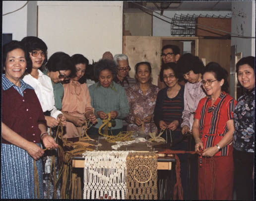 Filipino women and men learing to do macrame at the Silayan Filipino Community Centre