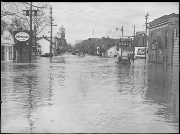 Historic photo from Tuesday, March 16, 1948 - Flood scene, Brampton main street 1948 - water almost to the top of car doors in Brampton